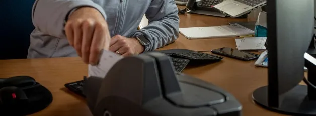 A laptop, mug, phone, and notepad laid out on a desk